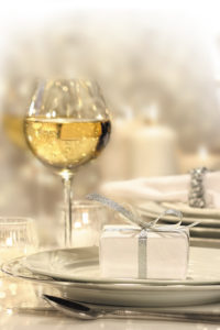 Festive table setting with silver ribbon gift on plate